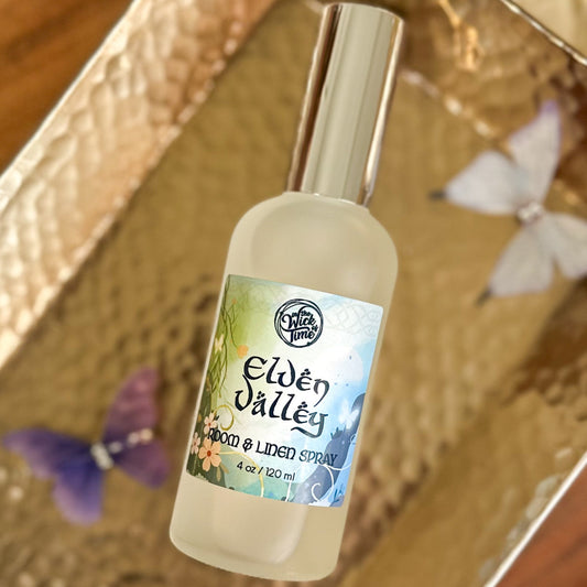 Elven Valley room and linen spray bottle on a textured surface with butterflies.