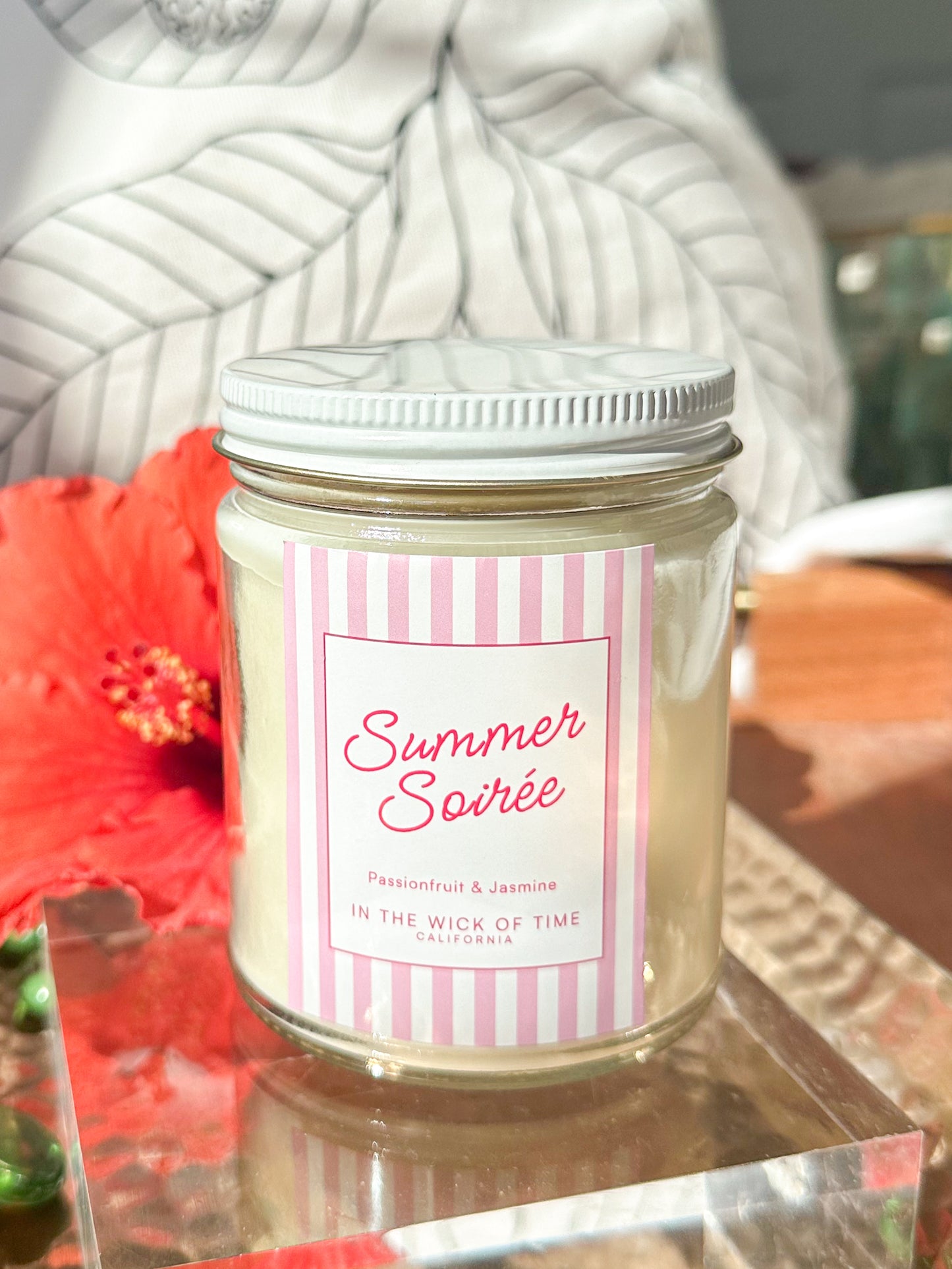 Soy candle called Summer Soiree with a pink label and Passionfruit and Jasmine scents. 